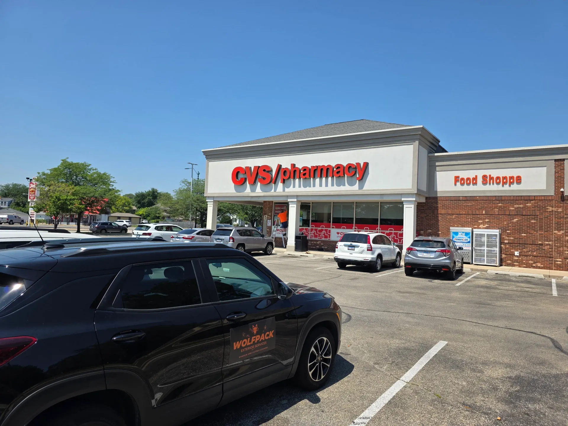CVS/pharmacy storefront and parking lot viewed from across the commercial property.