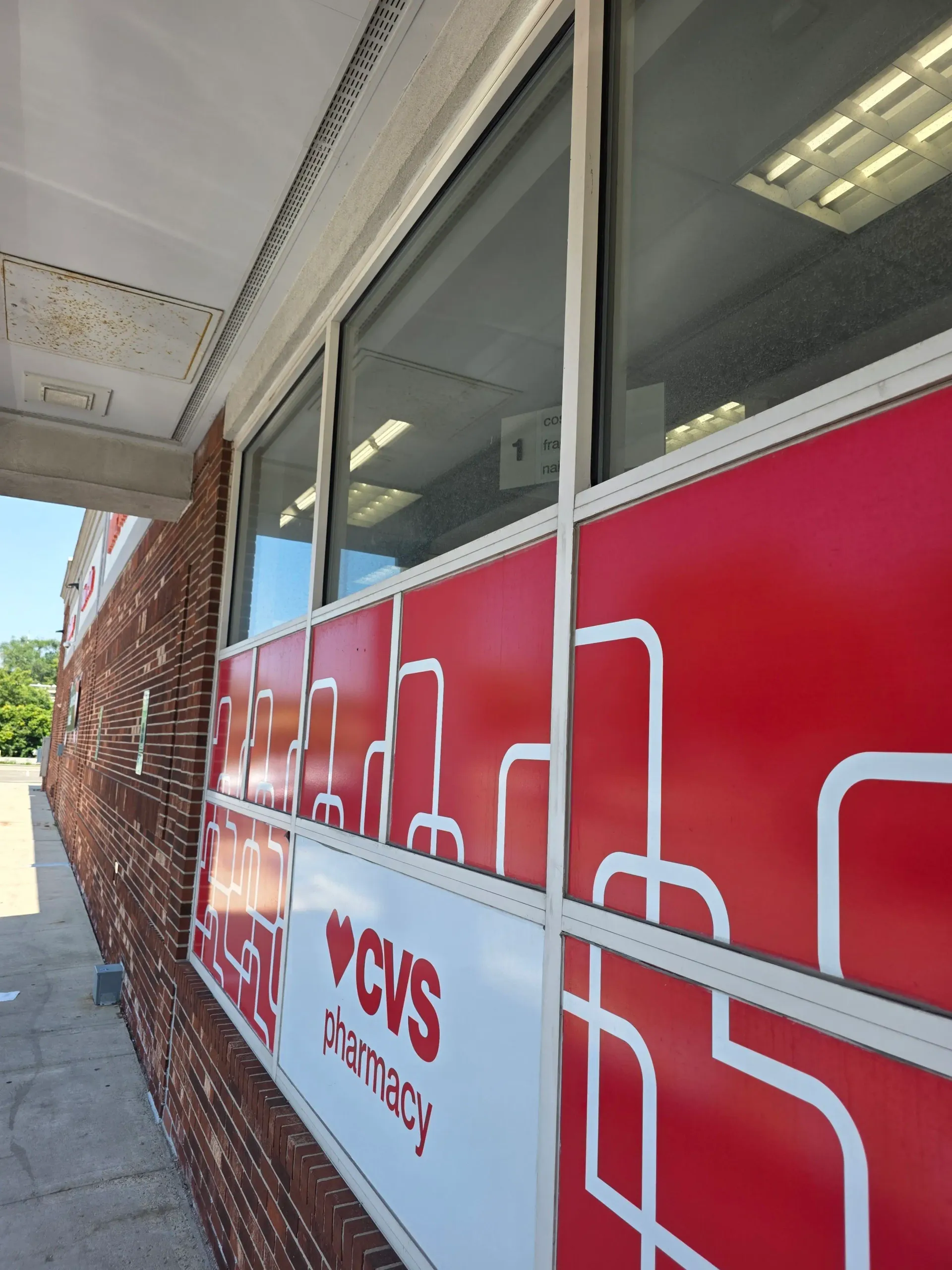 Close view of completed commercial window cleaning on CVS/pharmacy storefront glass.