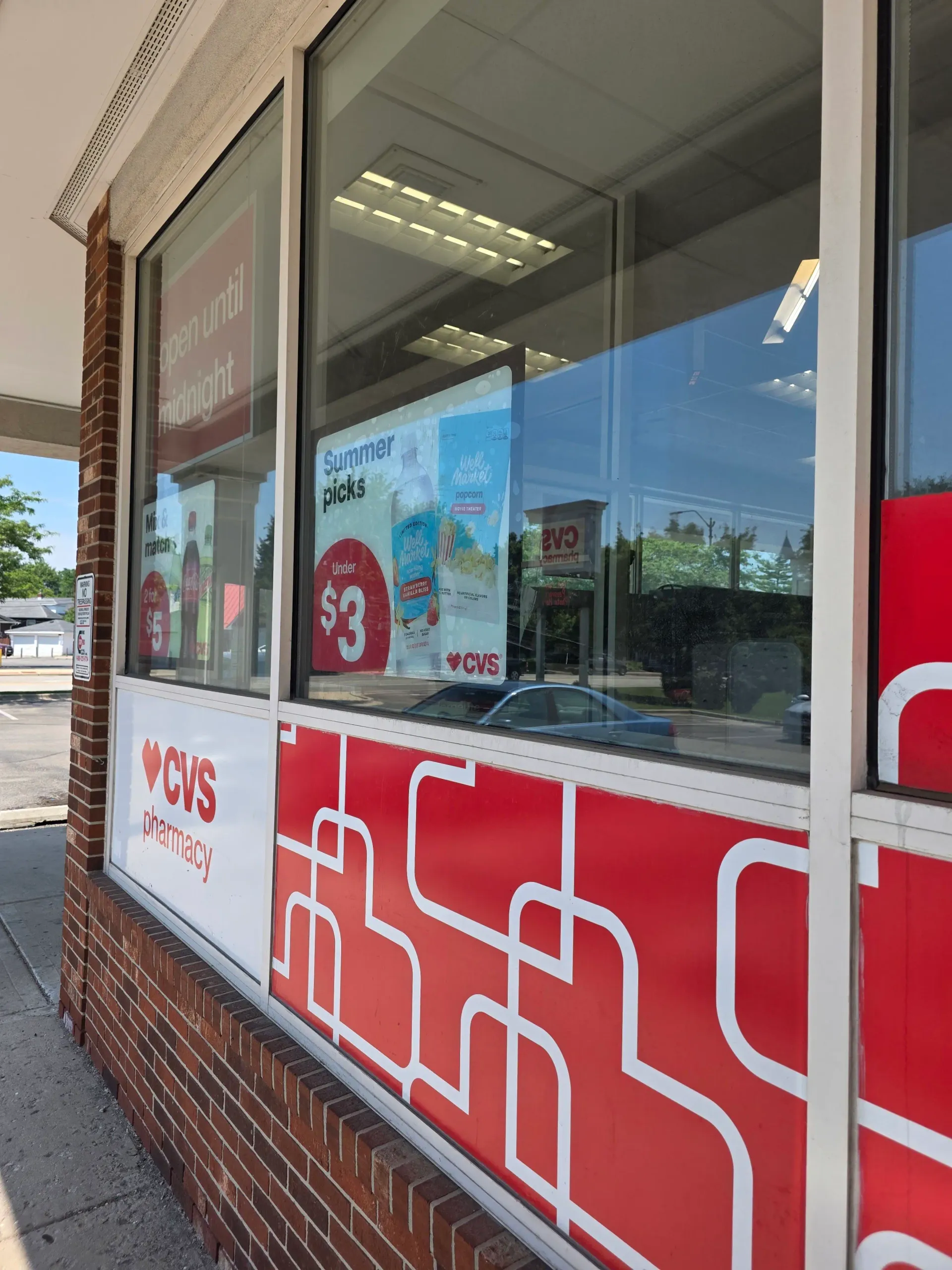Corner view of commercial storefront windows with red CVS/pharmacy graphics.