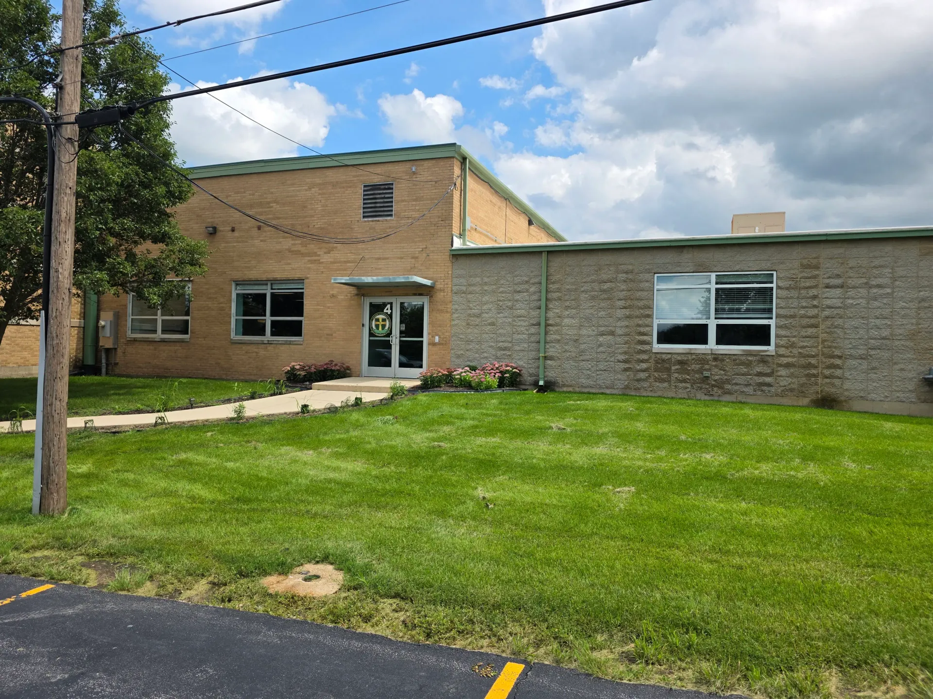 Commercial building facade with a lawn and multiple exterior windows.
