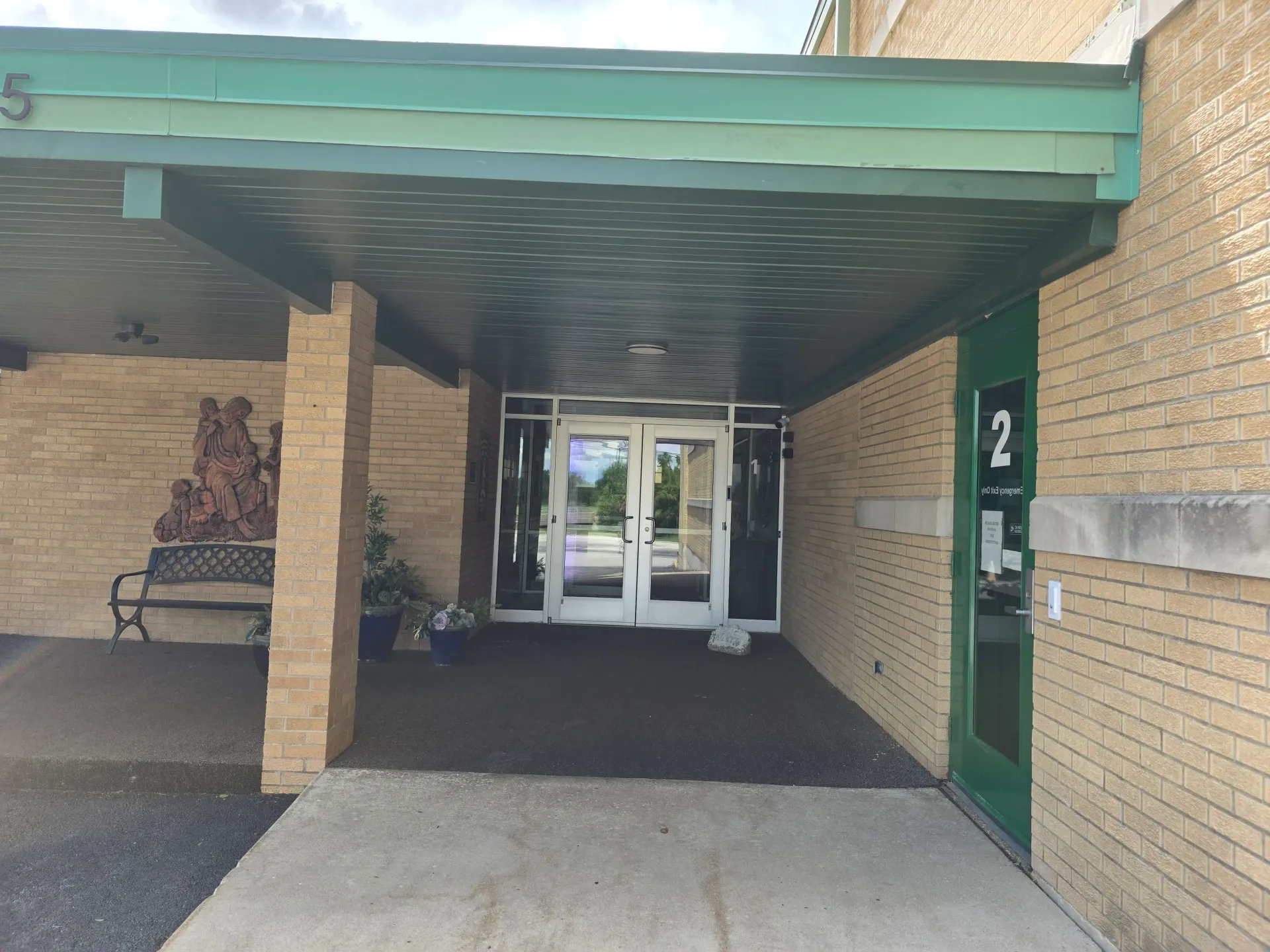 Covered commercial entrance with glass doors and cleaned surrounding windows.